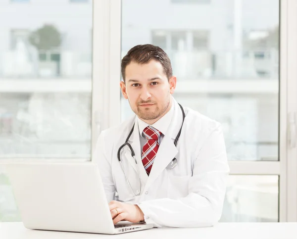 Giovane medico maschio che lavora nel suo studio — Foto Stock