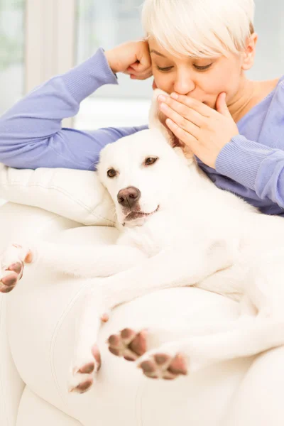 Mulher loira está brincando com seu cão — Fotografia de Stock