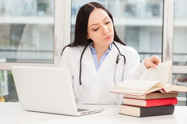 Kobieta lekarz studiuje z książki — Zdjęcie stockowe