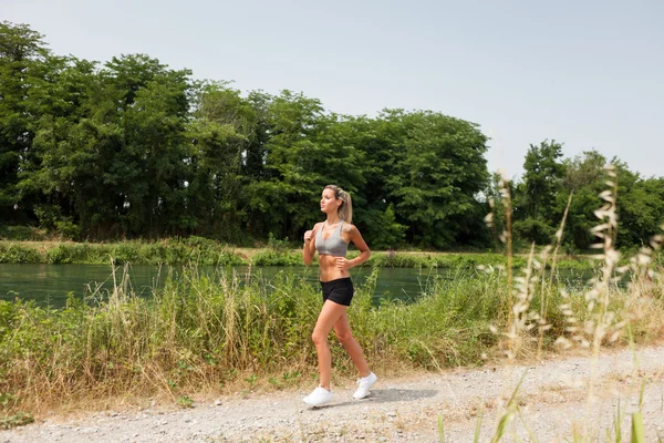 Beautiful blonde woman is doing running workout — Stock Photo, Image