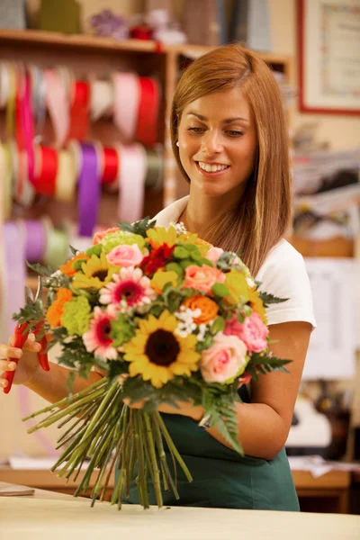 Florista feminina está criando um buquê colorido — Fotografia de Stock