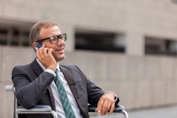 O empresário na cadeira de rodas está a telefonar. — Fotografia de Stock