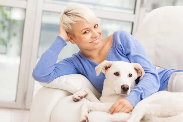 Vrouw zitten met jonge hond op de Bank — Stockfoto