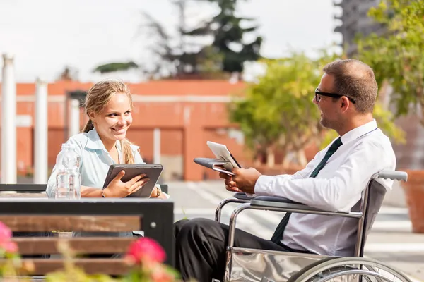 Businessman on wheelchair talks to his colleague — Stock Photo, Image