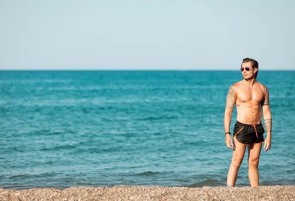 Portret van mannen die zich voordeed op het strand — Stockfoto