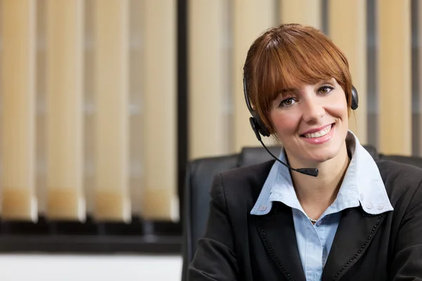 Female support assistant working at the helpdesk — Stock Photo, Image