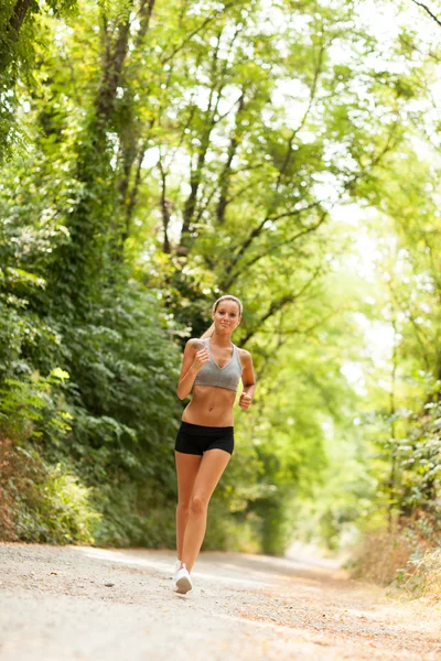 Mooie blonde vrouw doet lopende training — Stockfoto