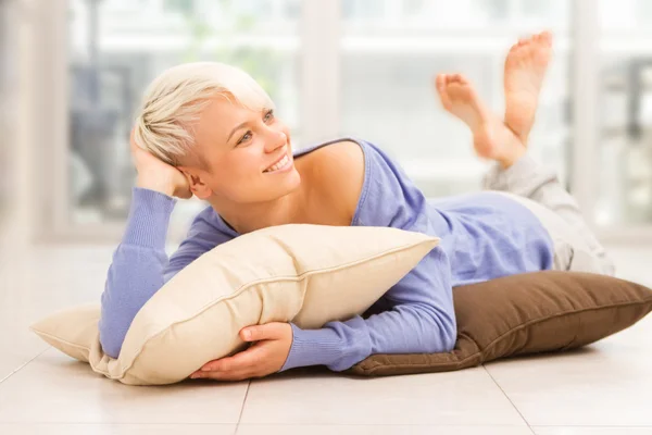 Smiling woman with short hairs laying on a pilow — Stock Photo, Image