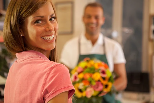 Donna sta comprando un bouquet colorato di fiori Foto Stock