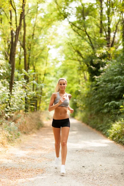 Mooie blonde vrouw doet lopende training — Stockfoto