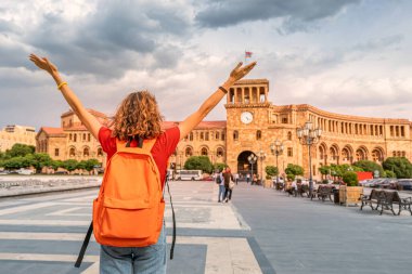 Sırt çantalı mutlu öğrenci ellerini kaldırdı ve Erivan Cumhuriyet Meydanı 'nın ana turistik cazibesinin muhteşem manzarasına seviniyor.