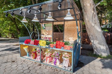 Birçok farklı çiçek ve buketler bir kaldırım dükkanında satılıktır ya da insanlar olmadan fiyat etiketleri ile tezgahtır.