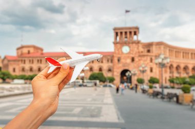 Erivan 'daki bir Cumhuriyet Meydanı' nın arka planında oyuncak uçağı olan turist kadın. Ermenistan 'da hava ulaşımı kavramı