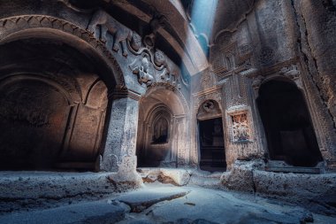 Kayaya oyulmuş meşhur Geghard Manastırı 'nın ve kilisenin içi. Bir ışık huzmesi, salonda aslanları tasvir eden eski bir levrek kabartmasını aydınlatır.