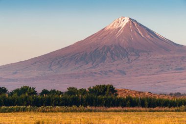 Kız Kardeş Dağı ya da Küçük Ararat ideal konik volkan şeklinde. Kalderalı ve buzullu zirve yükselen güneşle aydınlanır..