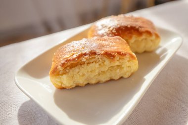 Lezzetli ve tatlı hamur işleri tabakta Pencereden sabah ışığı geliyor