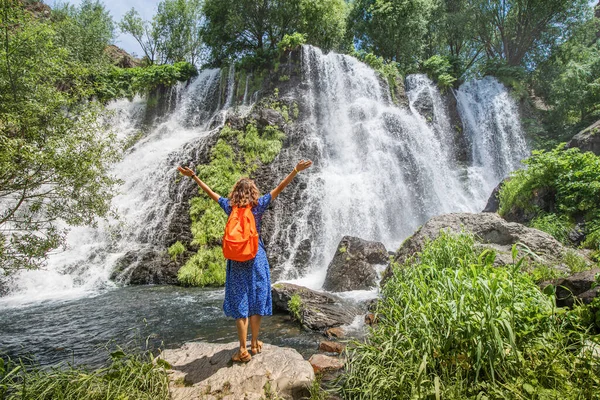 在亚美尼亚美丽而巨大的Shaki瀑布附近 一个背着背包的快乐的女孩旅行者躺在那里 淡水和旅游景点概念 — 图库照片