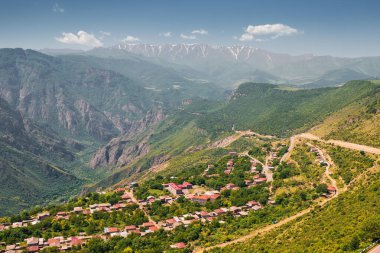 Dağ vadisindeki küçük bir kasaba ya da köyün havadan görünüşü. Uzakta küçük bir sis yüzüyor ve tepenin üstünde kar var.