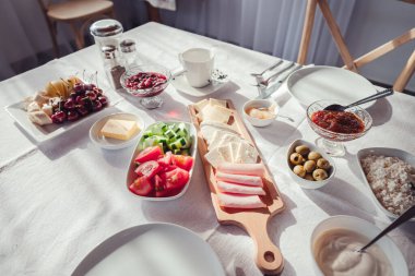 Oteldeki sette kar beyazı bir masa örtüsünün üzerinde çeşitli abur cuburlarla Avrupalı kahvaltısı.