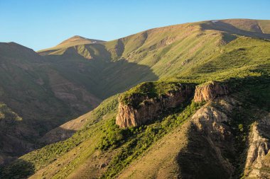 Dağların tepeleri ve kayaları batan güneşin ışınlarıyla aydınlatılan inanılmaz bir desen oluşturur. Işık ve gölgenin oyunu