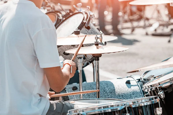 A musician plays the drums in close-up on the street. Concert and rock festival concept
