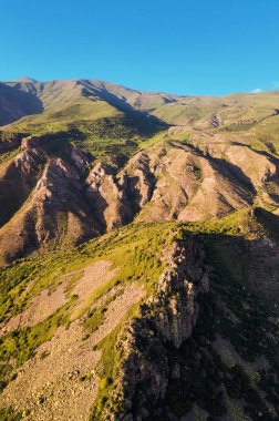 Dağlardaki kayalıkların ve kayaların havadan görünüşü batan güneşin ışınlarıyla aydınlatılan şaşırtıcı bir şablon oluşturur. Jeolojik çıkıntılar ve kir kavramı