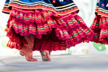 Dekore edilmiş geleneksel Bashkir eteği dans sırasında ön planda dönen kırmızı çizmelerle kıvrılır.