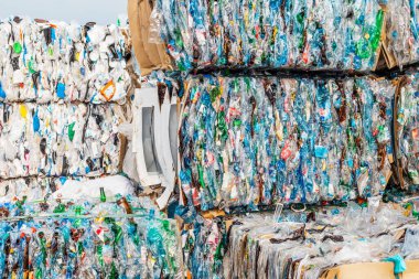 Bir sürü plastik çöp pres tarafından sıkıştırılır ve atık işleme tesisine taşınması için paletlere bağlanır.