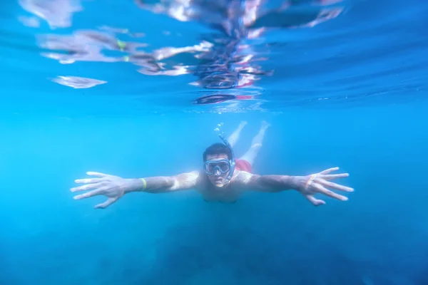 若くて幸せな男はアマチュアレベルで水中でシュノーケリングを楽しんでいます 水深が狭い水中での写真 — ストック写真