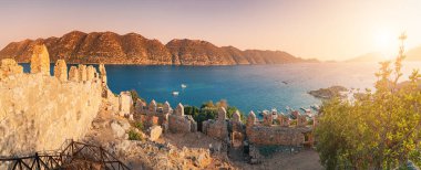 Famous Simena ancient castle on a top of a hill with stunning panoramic view over the sea at sunset time. Travel and tourist attractions at Kekova island, Turkey.