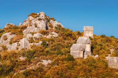 Türkiye 'nin Kekova adası yakınlarındaki dağın tepesindeki Lycia Yunan medeniyetinin antik mezarları. Antalya bölgesinde turizm merkezleri