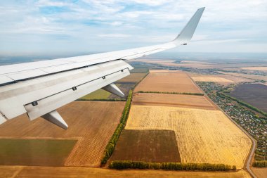 Yolcu koltuğundan lomboza ve uçağın kanadının kırsal alanlarda uçuşu.