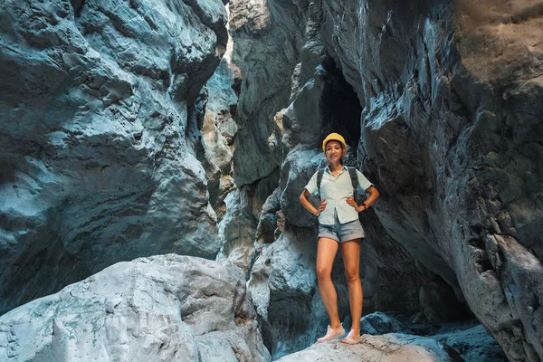 Happy alone woman wearing helmet for safety is engaged in active canyoning and hiking along the Saklikent Gorge in Turkey. New experience and outdoor leisure recreation