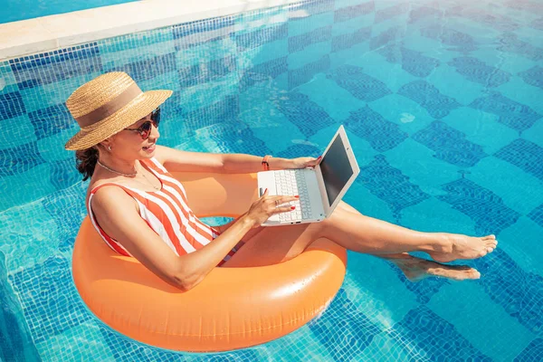 Frau Badeanzug Schwimmt Aufblasbaren Kreis Schwimmbad Und Surft Laptop Internet — Stockfoto