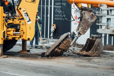 21 Ekim 2021, Selanik, Yunanistan: Ağır makineler eski asfalt tabakasını bir şehir caddesinde pnömatik bir matkapla kaldırıyor.
