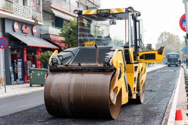 21 Ekim 2021, Selanik, Yunanistan: Roller Paver, şehir caddesi inşaatı sırasında asfaltı dümdüz ediyor