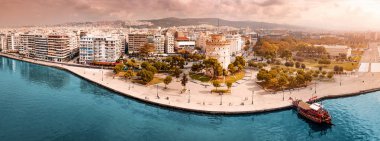 Selanik şehrinin ana sembolü Beyaz Kule 'nin rıhtımda tekne turu gemisi olan hava manzarası. Yunanistan 'da seyahat işaretleri ve kentsel kalkınma kavramı.