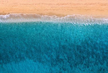 Gökyüzü manzaralı cennet gibi kumlu bir sahil. Gelen gök mavisi bir dalga. Tropikal ülkelerde tatil ve rahatlama kavramı. Seyahat ve tatil için arka plan