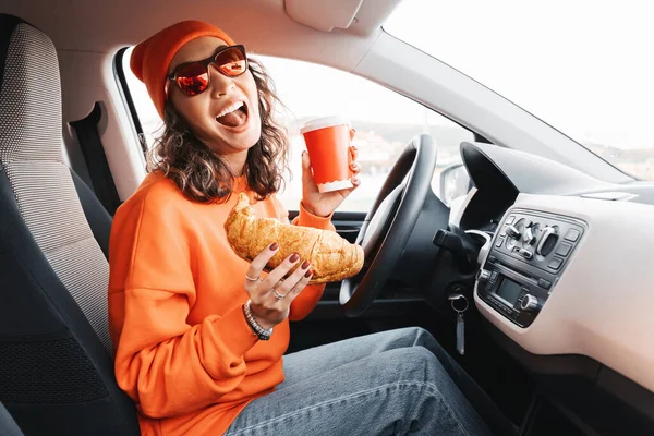 운전자는 운전하면서 커피를 마시고 크로와 패스트푸드 운전을 명령한다는 — 스톡 사진