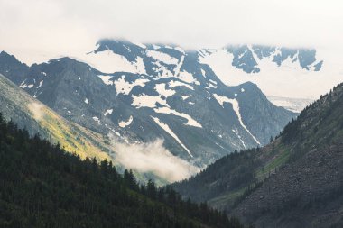 Vadide yamaçları olan ilham verici bir manzara ve sonbahar zamanı kar ve buzullarla kaplı uzak dağlar.