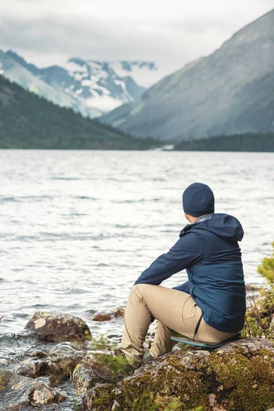 Erkek Bir Yürüyüşçü Maceracı Resimli Bir Dağ Gölünün Kıyısında Oturur — Stok fotoğraf