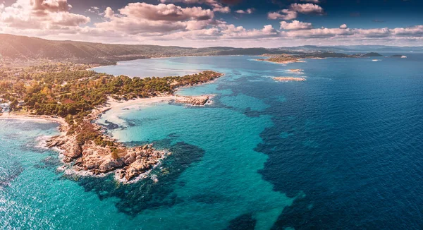 Türkuaz suyun çeşitli tonlarıyla cennet sahili havadan görünüyor. Yunanistan 'ın Vourvourou tatil köyündeki derin ve tenha kumlu sahillerdeki mercan resifleri