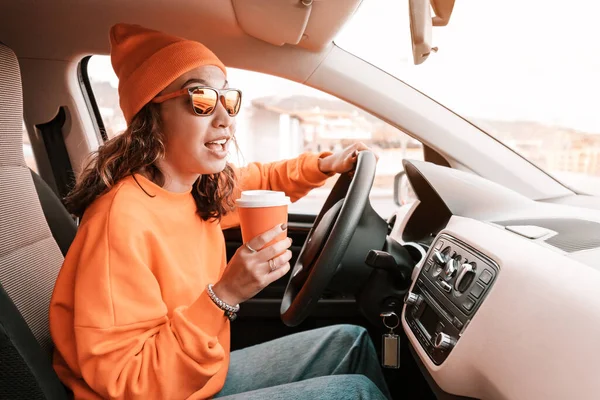 여학생 도시의 거리를 자동차를 다닙니다 손에는 커피를 있습니다 — 스톡 사진