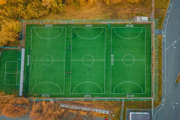 Aerial view of amateur mini football playground with practicing and training sportsmans