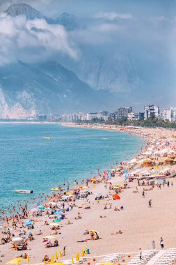 04 June 2022, Antalya, Turkey: Crowded city beach with hundreds of vacationers and tourists resting, sunbathing and swimming at extremely hot summer day in resort town