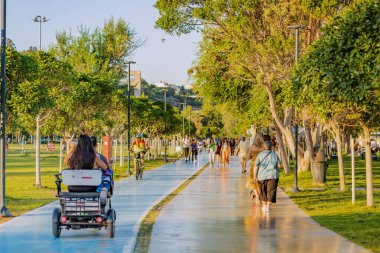 17 June 2022, Antalya, Turkey: There is a bicycle and a pedestrian path on the Antalya embankment. People are walking and enjoying the weather and the weekend