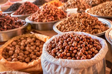 hazelnuts in shell, walnut and other nuts and dried fruits and raisins on the farmers counter at the local market or oriental bazaar