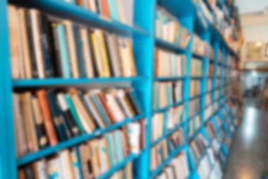 Blurred background from a library with lots of books on the shelves. Education and learning concept