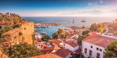 Aerial sunset view of the picturesque harbor with marina port with cruise tourist ships and ancient fortress walls in Antalya. Turkish Riviera and resort paradise