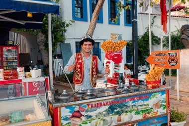 21 June 2022, Antalya, Turkey: Funny seller of traditional Turkish ice cream making humorous show and tricks before selling dondurma